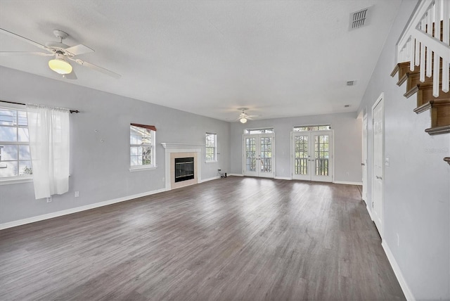 unfurnished living room featuring french doors, dark wood-style flooring, a fireplace, and visible vents