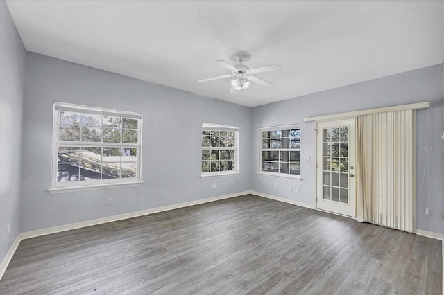 spare room with ceiling fan, baseboards, and wood finished floors