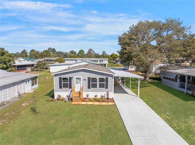 view of front of house featuring concrete driveway, an attached carport, and a front yard