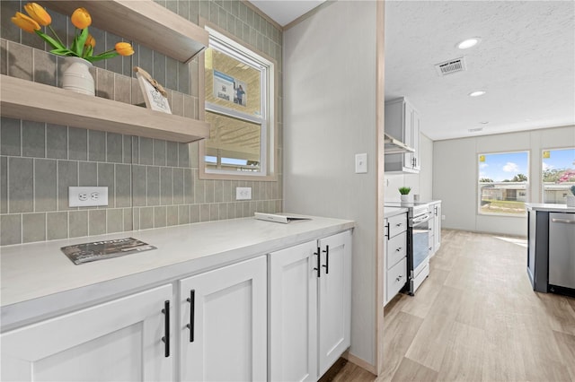 kitchen with visible vents, white cabinets, appliances with stainless steel finishes, backsplash, and open shelves