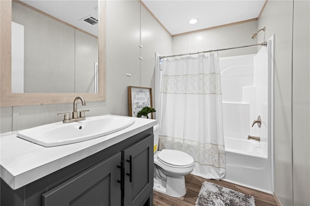 bathroom featuring toilet, wood finished floors, visible vents, vanity, and shower / bathtub combination with curtain