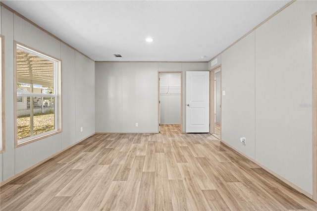 empty room featuring ornamental molding and light wood-style floors