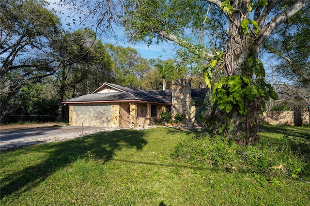 view of front of house featuring an attached garage, concrete driveway, and a front yard