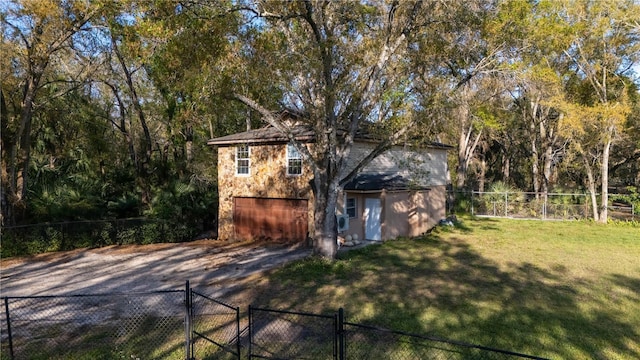 view of outbuilding featuring driveway, an attached garage, a gate, and fence