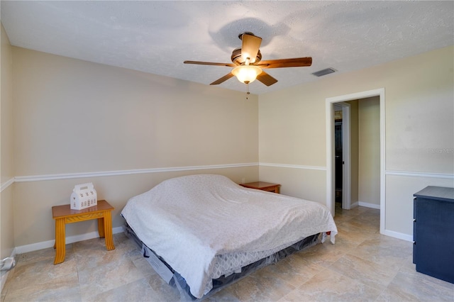 bedroom with a textured ceiling, visible vents, and baseboards