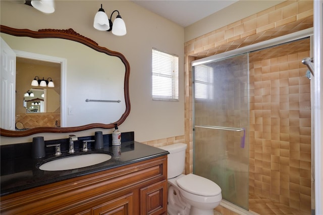 bathroom with toilet, a stall shower, and vanity