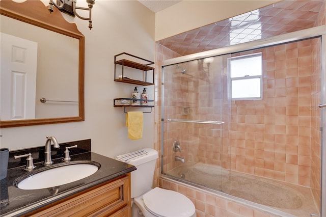 full bathroom with combined bath / shower with glass door, vanity, and toilet