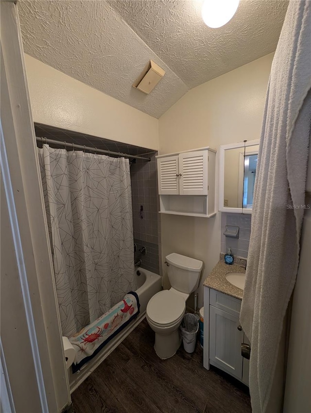 bathroom featuring lofted ceiling, a textured ceiling, toilet, wood finished floors, and vanity