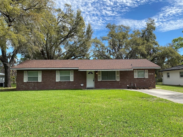 single story home with brick siding, concrete driveway, and a front lawn