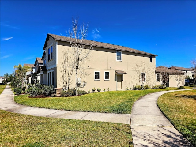 view of side of home with a lawn and stucco siding