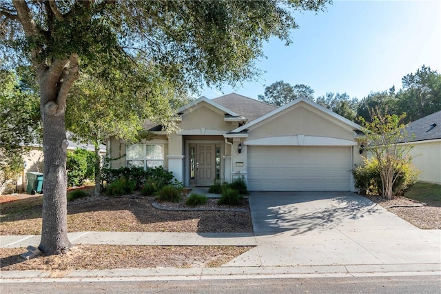 ranch-style house with a garage, concrete driveway, and stucco siding