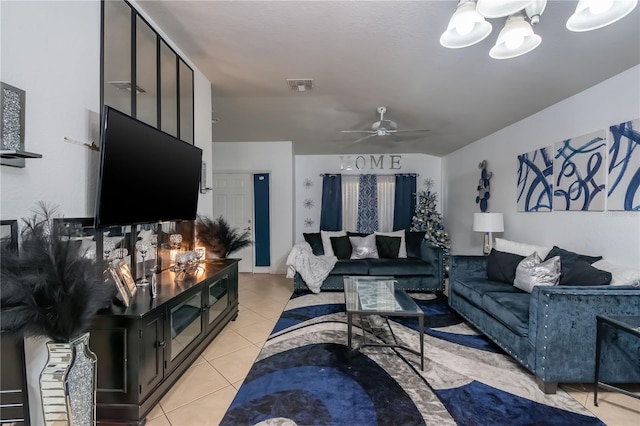 living area featuring light tile patterned floors, ceiling fan with notable chandelier, and visible vents