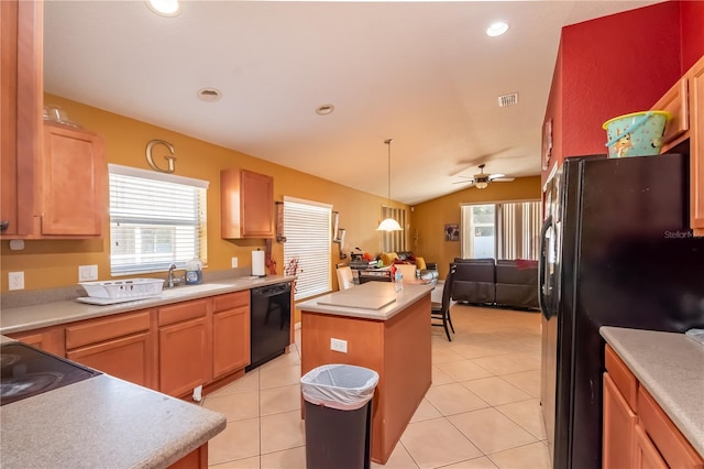 kitchen with a center island, light tile patterned floors, lofted ceiling, light countertops, and black appliances