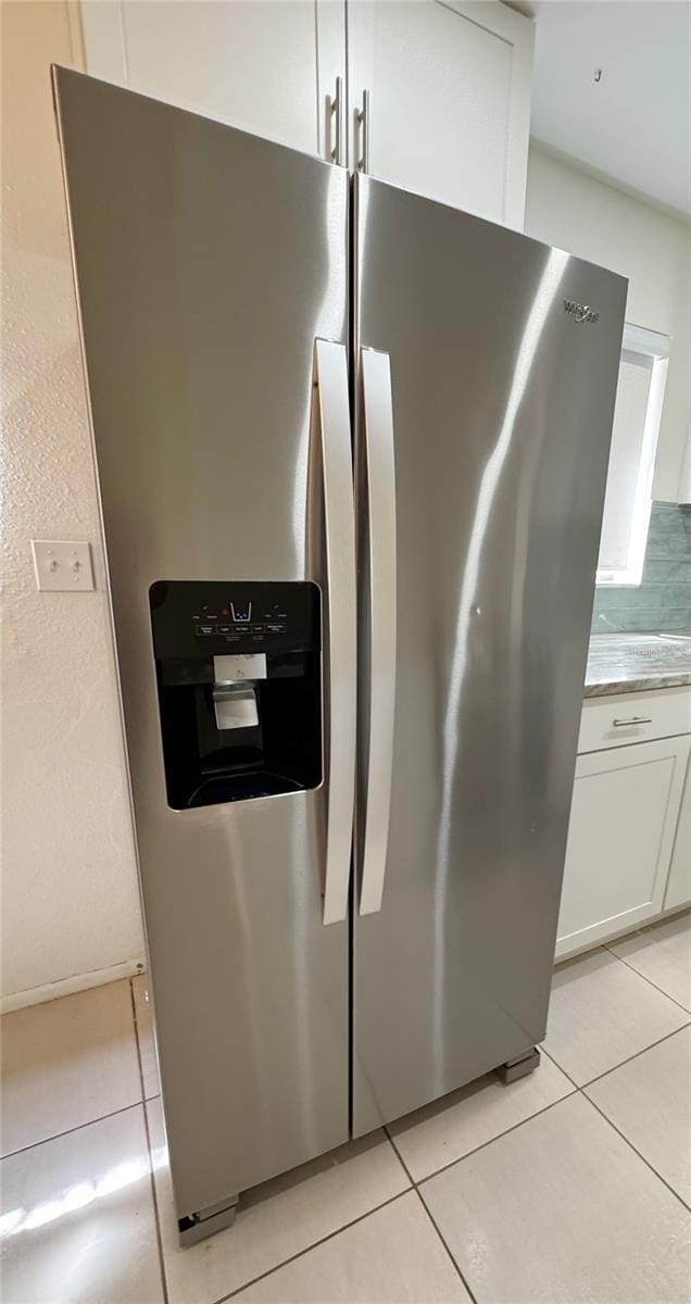 3300 Fox Chase Cir N Unit 229, Palm Harbor, FL 34683 - kitchen view of stainless steel fridge, white cabinetry, and light countertops