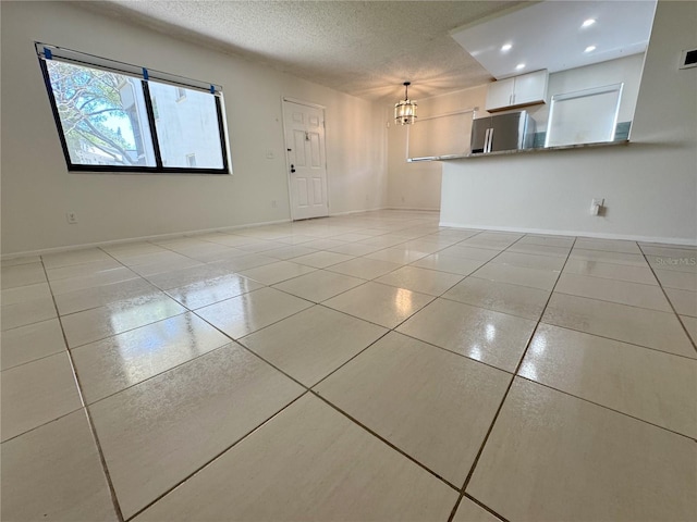 3300 Fox Chase Cir N Unit 229, Palm Harbor, FL 34683 - unfurnished living room with light tile patterned floors, recessed lighting, a textured ceiling, baseboards, and a chandelier