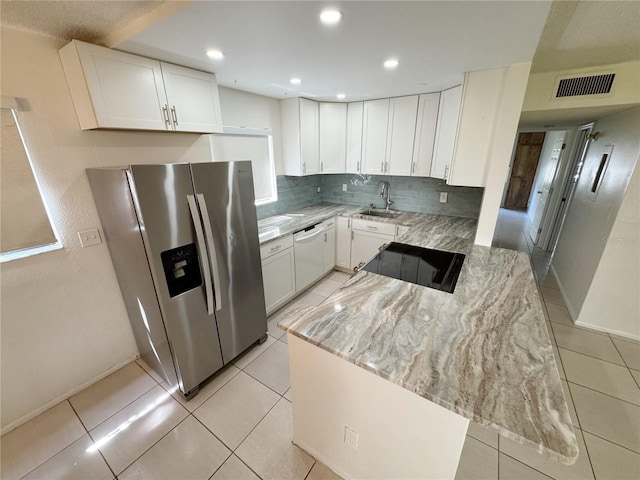 3300 Fox Chase Cir N Unit 229, Palm Harbor, FL 34683 - kitchen featuring stainless steel refrigerator with ice dispenser, white dishwasher, a sink, light stone counters, and white cabinets