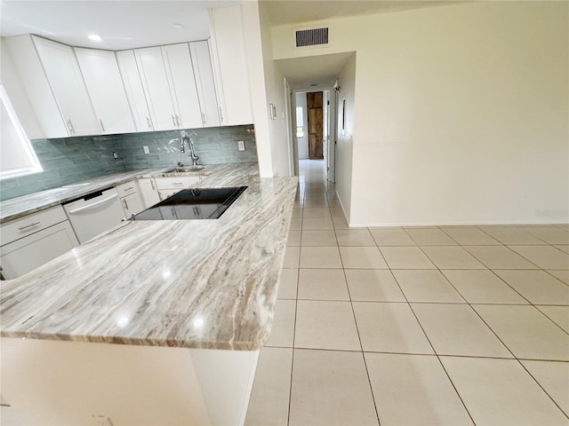 3300 Fox Chase Cir N Unit 229, Palm Harbor, FL 34683 - kitchen with dishwasher, a sink, tasteful backsplash, white cabinetry, and light stone counters
