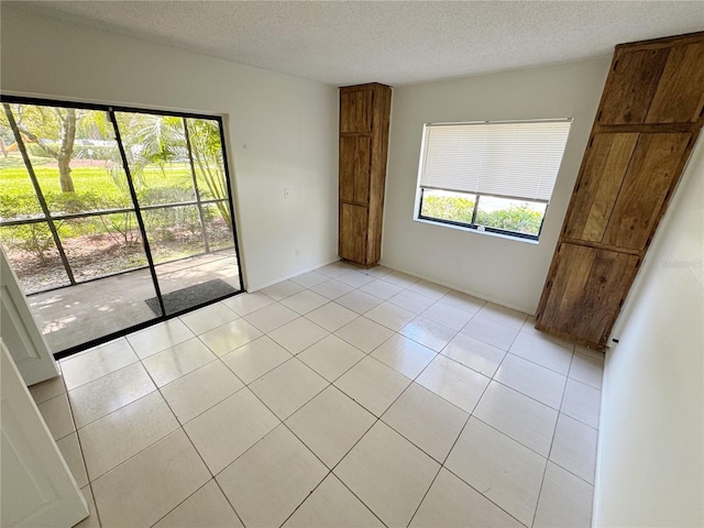 3300 Fox Chase Cir N Unit 229, Palm Harbor, FL 34683 - unfurnished bedroom with a textured ceiling, light tile patterned floors, and access to exterior