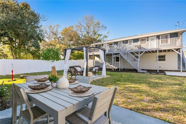 view of patio with a deck, outdoor dining space, stairway, and a fenced backyard