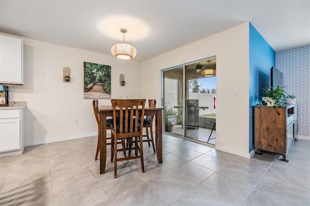 dining space featuring light tile patterned flooring, baseboards, and wallpapered walls