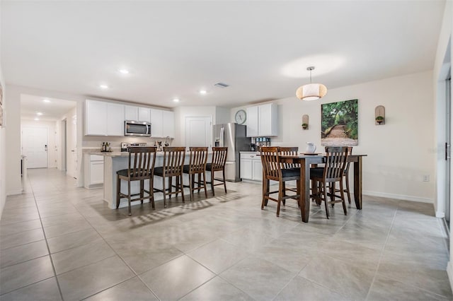 dining room with baseboards, light tile patterned flooring, visible vents, and recessed lighting