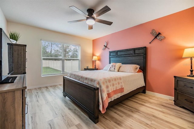 bedroom featuring baseboards, a ceiling fan, and light wood-style floors