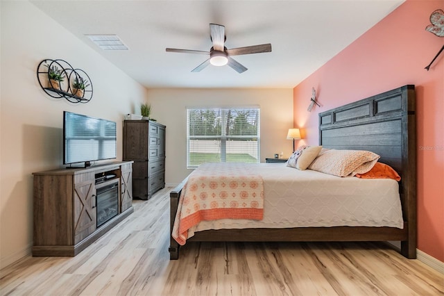 bedroom featuring light wood-type flooring, visible vents, ceiling fan, and baseboards