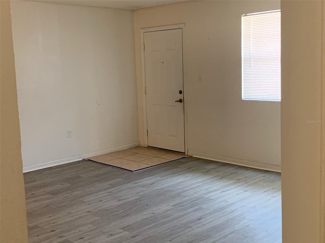 foyer with baseboards and wood finished floors