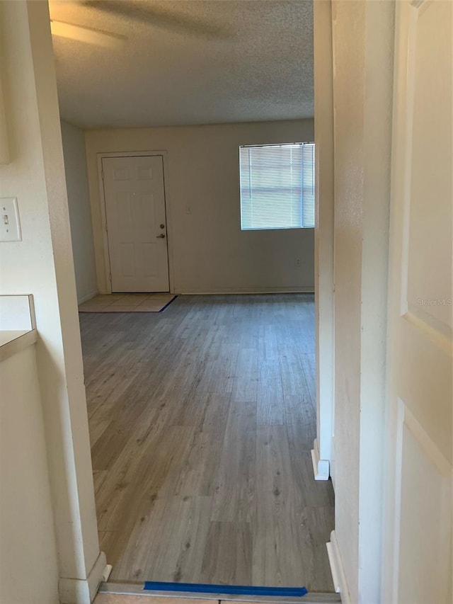 unfurnished room with wood finished floors and a textured ceiling