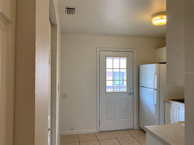 kitchen with light tile patterned floors, visible vents, white cabinets, and light countertops