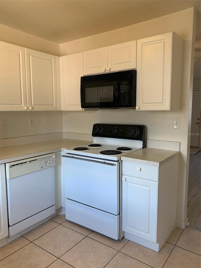 kitchen featuring light tile patterned floors, white appliances, white cabinetry, and light countertops