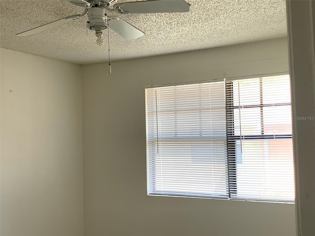 spare room with a textured ceiling and a ceiling fan