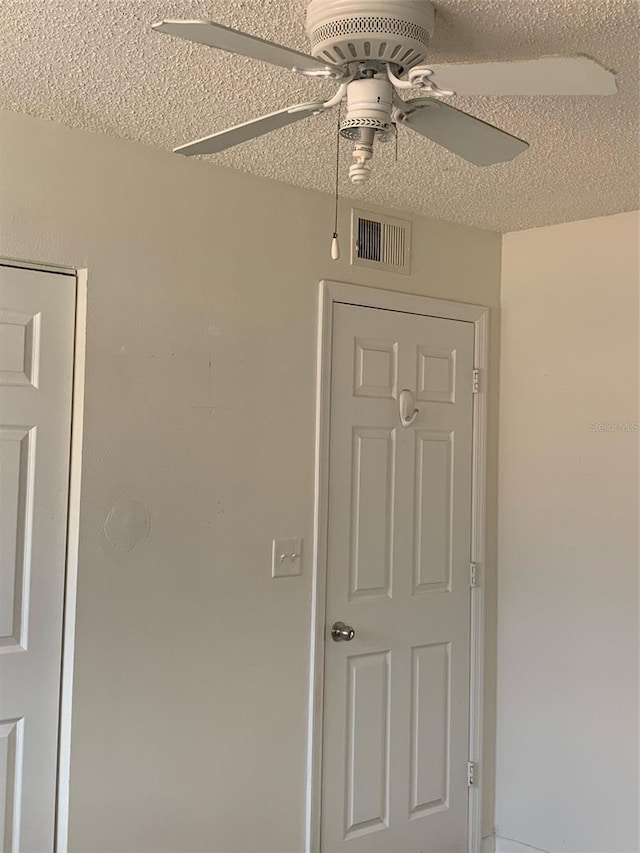 interior space featuring visible vents, a textured ceiling, and a ceiling fan