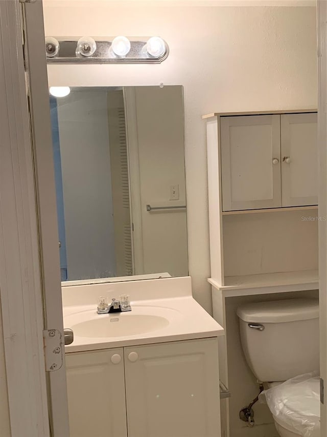 half bathroom featuring toilet and vanity