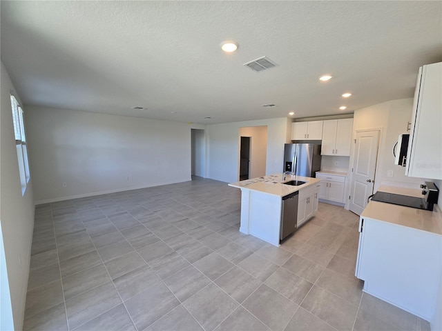 kitchen featuring stainless steel appliances, open floor plan, visible vents, and a center island with sink