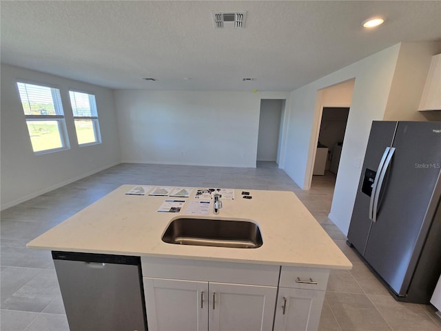 kitchen featuring a sink, visible vents, white cabinets, open floor plan, and appliances with stainless steel finishes