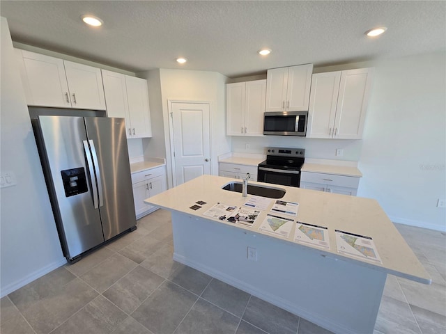 kitchen featuring a center island with sink, appliances with stainless steel finishes, white cabinets, and a sink