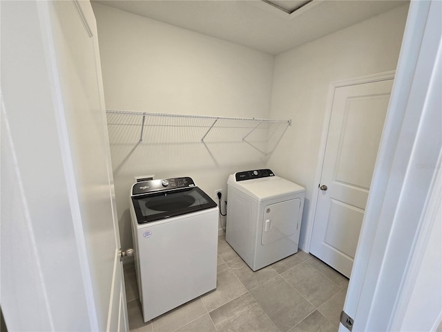 laundry area featuring light tile patterned floors, laundry area, and washing machine and clothes dryer