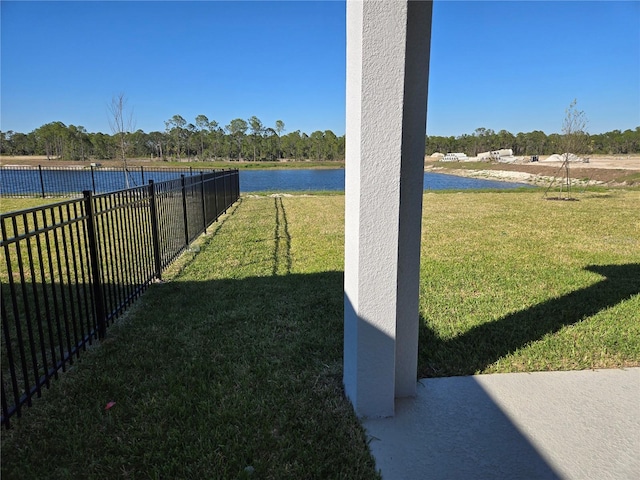 view of yard with a water view and fence