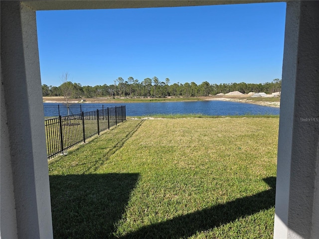 view of yard featuring a water view and fence