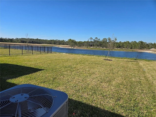 view of yard featuring a water view, cooling unit, and fence