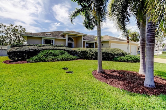 view of front of house featuring a front lawn, an attached garage, and stucco siding