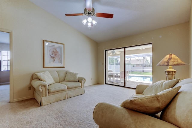 living area with lofted ceiling, ceiling fan, carpet flooring, and baseboards