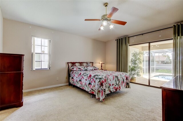 carpeted bedroom with ceiling fan, access to outside, multiple windows, and baseboards