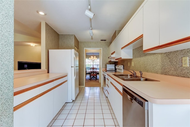 kitchen with light tile patterned flooring, white appliances, a sink, white cabinets, and light countertops