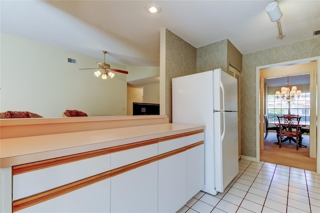 kitchen featuring light tile patterned floors, visible vents, freestanding refrigerator, white cabinets, and wallpapered walls