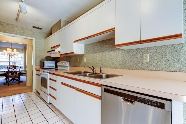 kitchen featuring white appliances, visible vents, light countertops, white cabinetry, and a sink