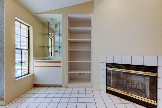 interior space featuring built in features, a tile fireplace, and a sink