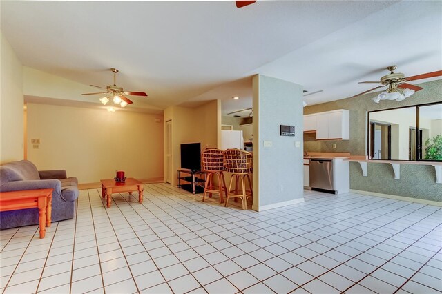 living room with a ceiling fan, light tile patterned flooring, and baseboards