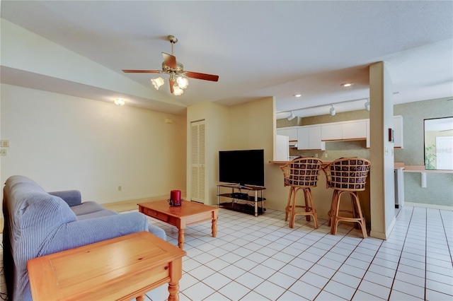 living room with light tile patterned floors, ceiling fan, and baseboards